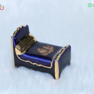 Adorno de porcelana con forma de cama color azul con filos dorados