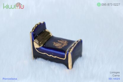 Adorno de porcelana con forma de cama color azul con filos dorados